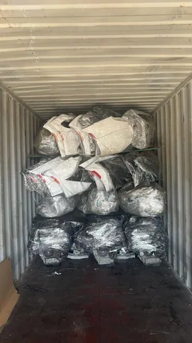 Wrapped automotive components arranged inside a shipping container at Engine Corner Auto Parts LLC.