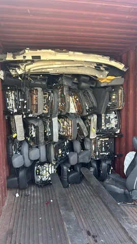Vehicle interior components arranged inside a shipping container at Engine Corner Auto Parts LLC.